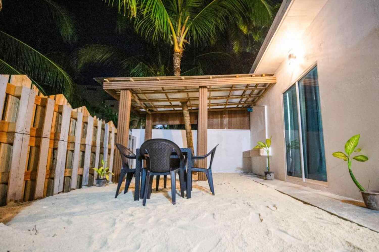 Outdoor terrace with table and chairs on the sand at Aquatic Mathiveri